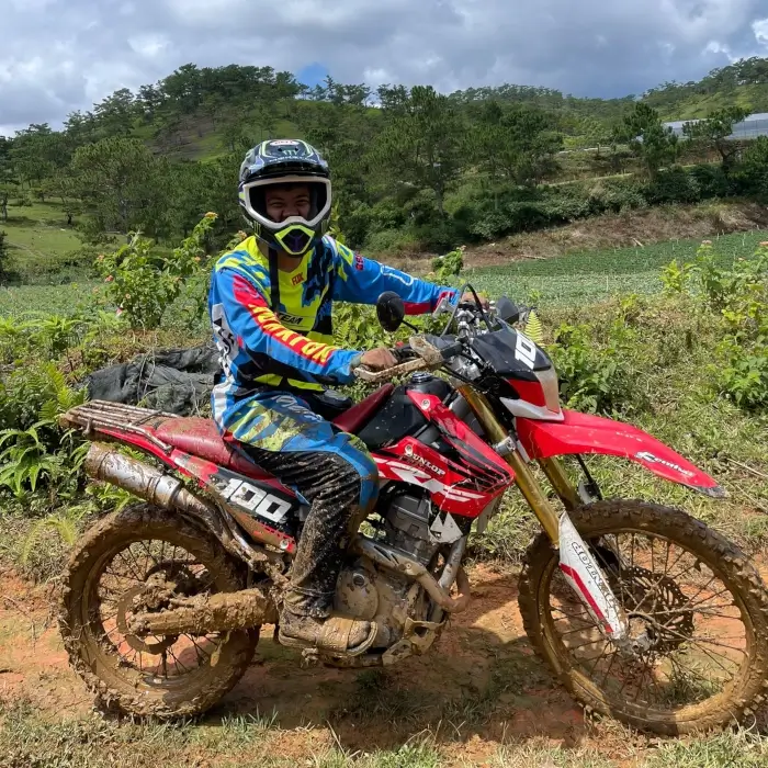 a guy on a dirtbike covered in mud.