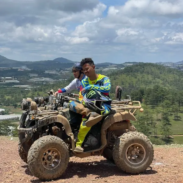 two guys on muddy atvs.