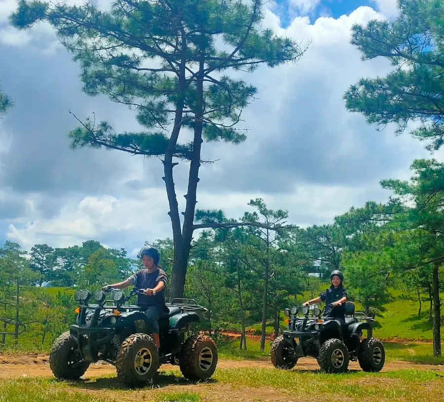 two girls riding atvs through the hills of da lat.